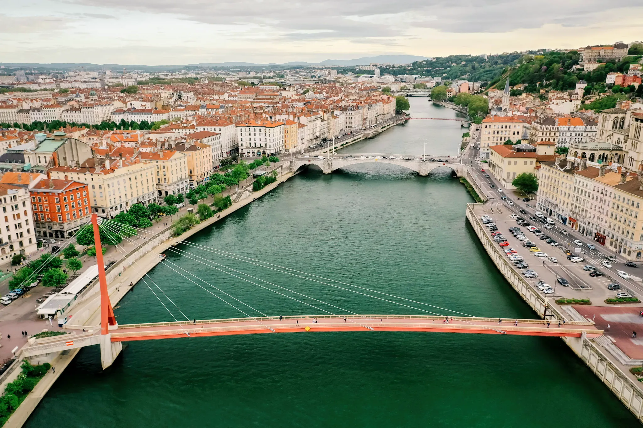 Voyages depuis Lyon - Vue aérienne de Lyon avec la Saône et la passerelle rouge, point de départ idéal pour voyager en Europe et en Méditerranée