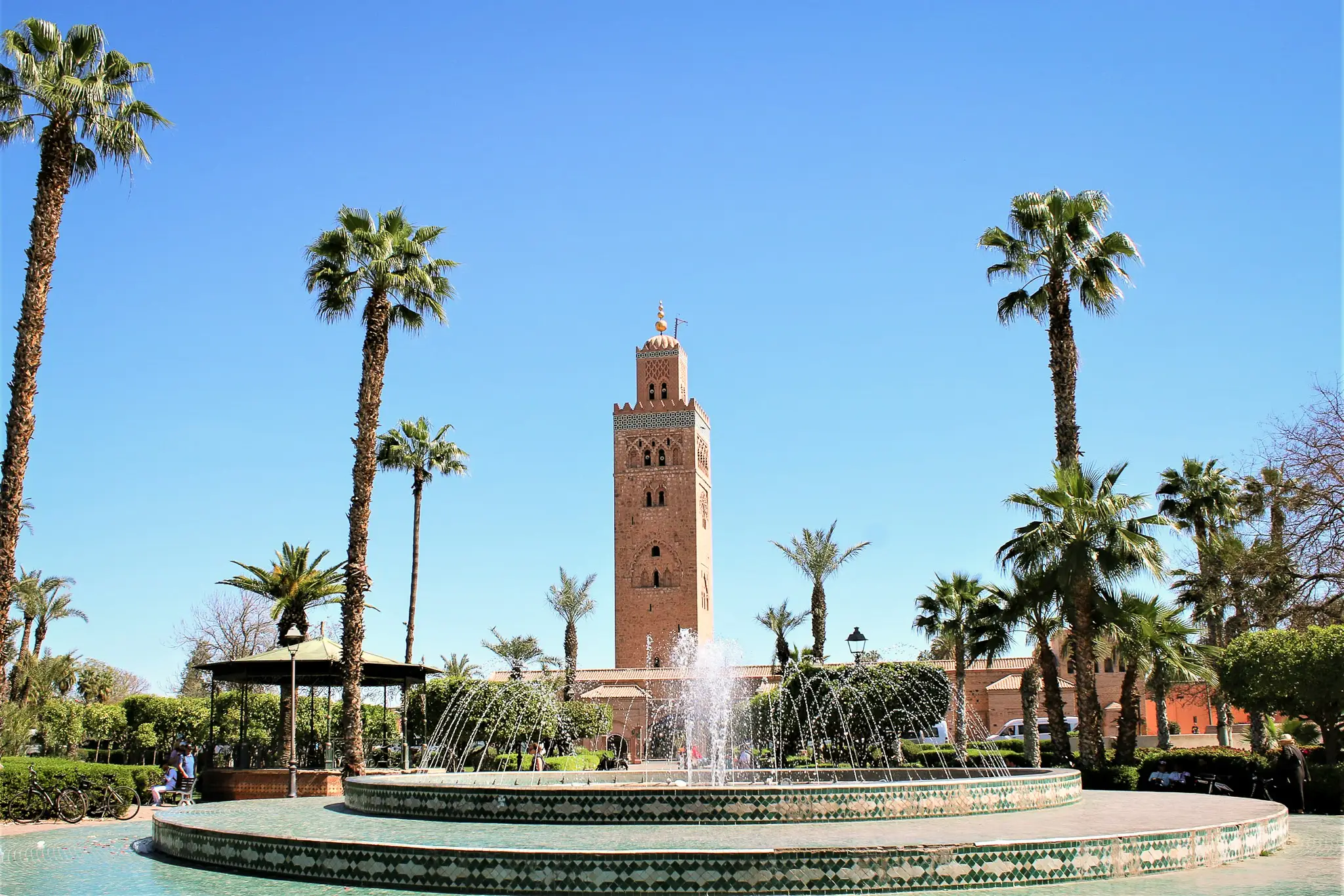 Minaret de la Koutoubia à l’heure bleue, palmiers et fontaine en premier plan - Marrakech