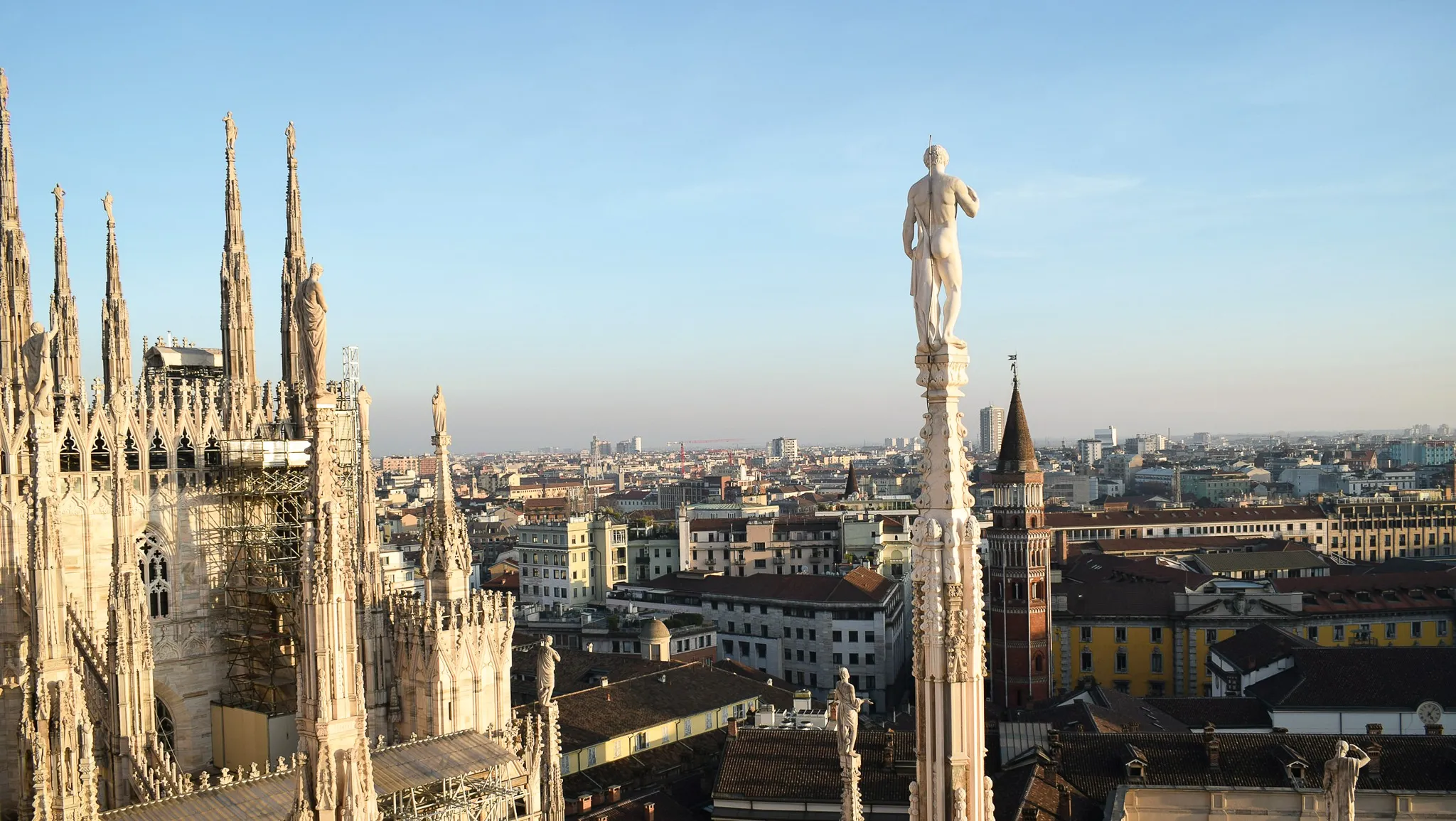 Visiter Milan en 5 jours - Terrasses du Duomo de Milan avec pinacles et vue sur la ville au coucher du soleil